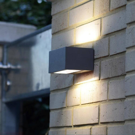 LED Außenwandlampe Gemini IP54 Anthrazit an einer Mauer montiert, das Up-&-Down-Licht erzeugt Lichteffekte.