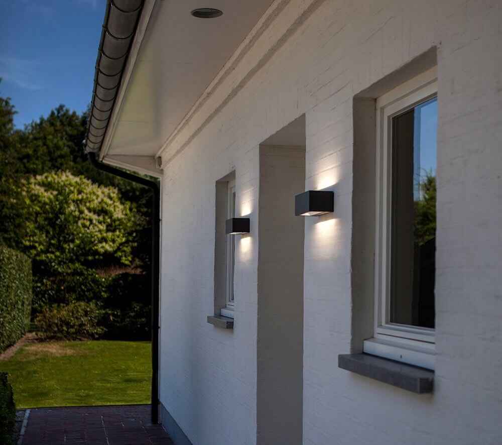 LED Außenwandlampe Gemini IP54 Anthrazit an der Wand eines modernen Hauses mit Lichtschatten.