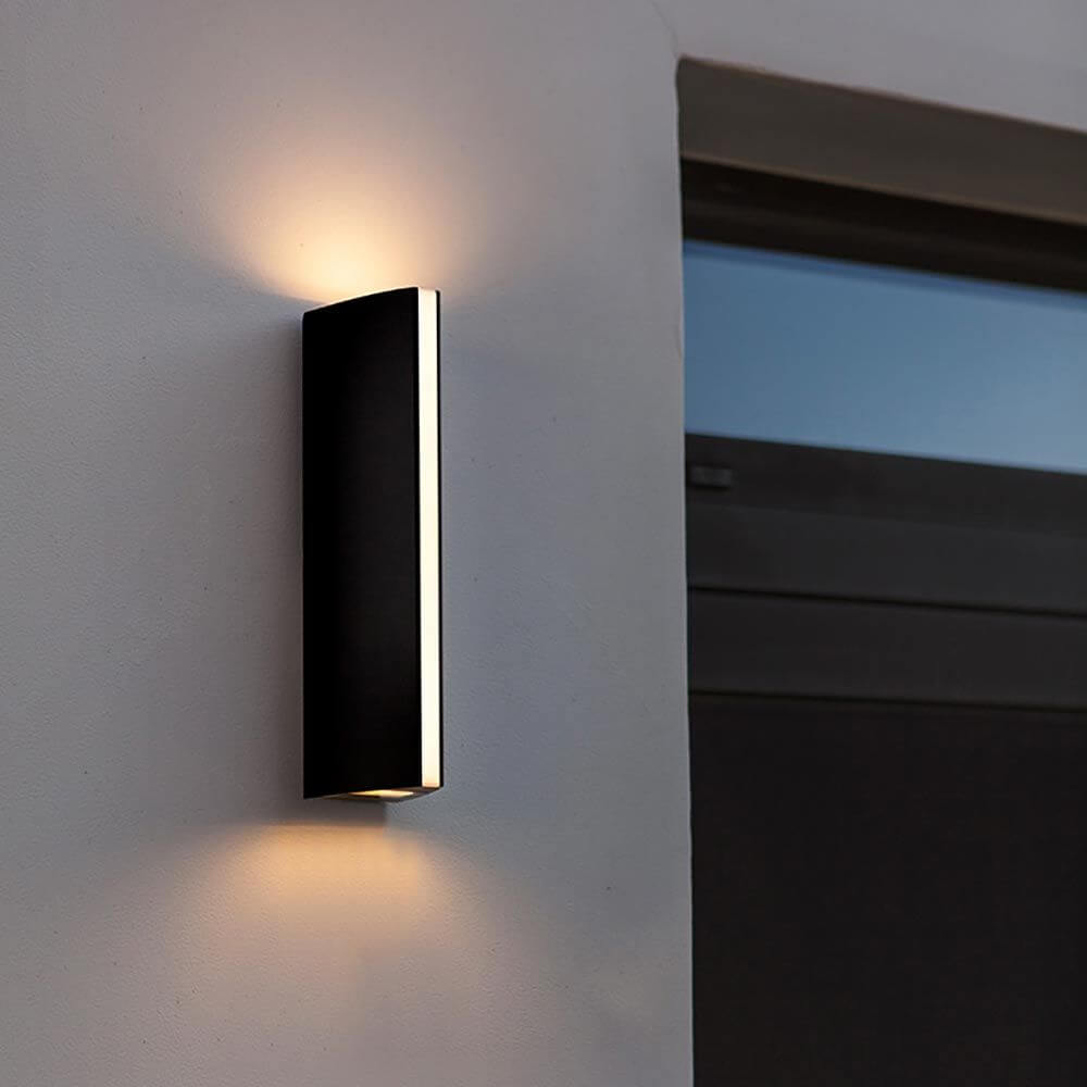 LED Außenwandlampe Leo IP44 Anthrazit an einer Wand, strahlend warmweißes Licht abgebend.