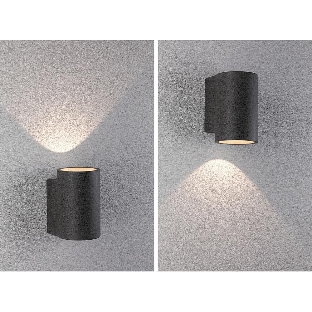 Beton LED Außenwandleuchte Concrea Sandig-Schwarz IP65 an grauer Wand mit indirektem Licht.