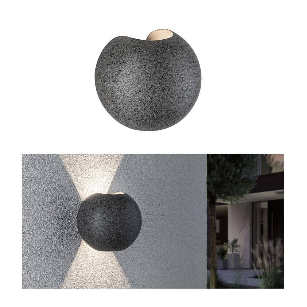 LED Außen Wandleuchte Concrea Schwarzer Sandstein Beton IP65 an einer Wand mit Lichtakzenten.