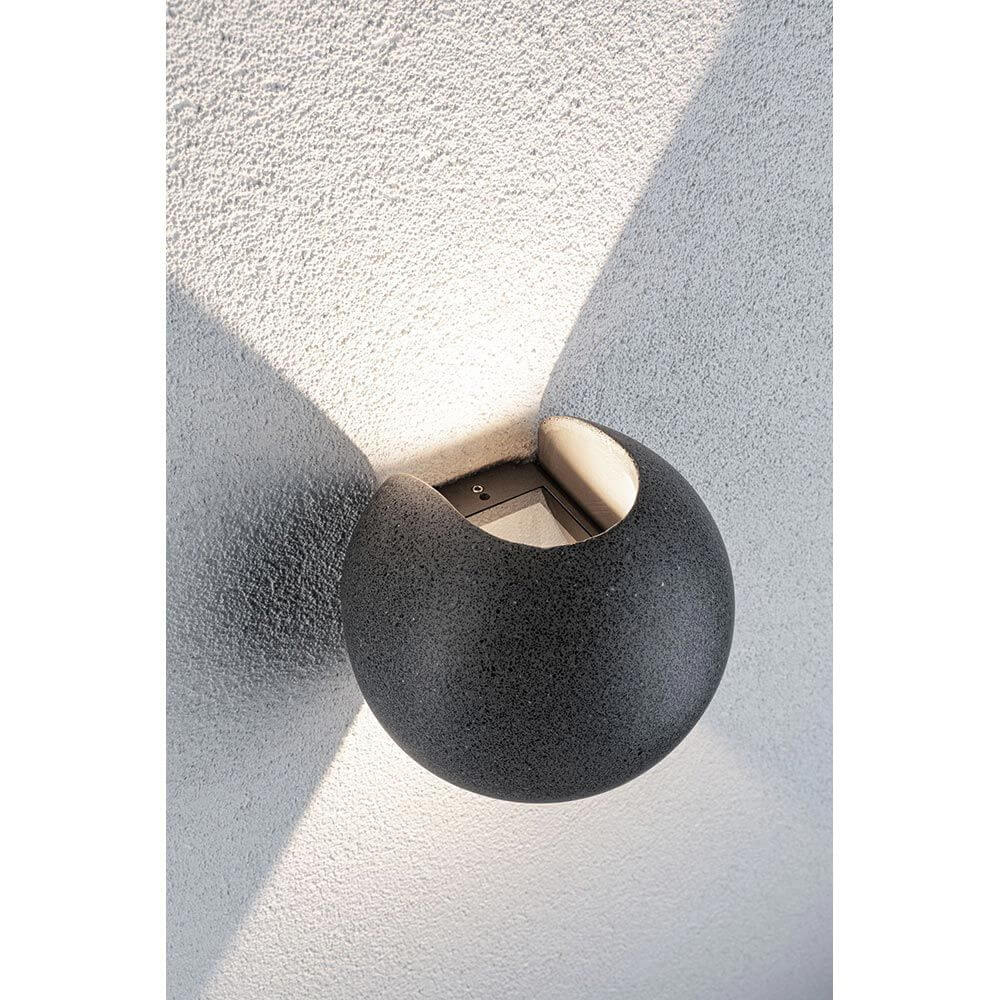 LED Außen Wandleuchte Concrea Schwarzer Sandstein Beton IP65 an Wand montiert, erzeugt attraktive Lichtakzente.
