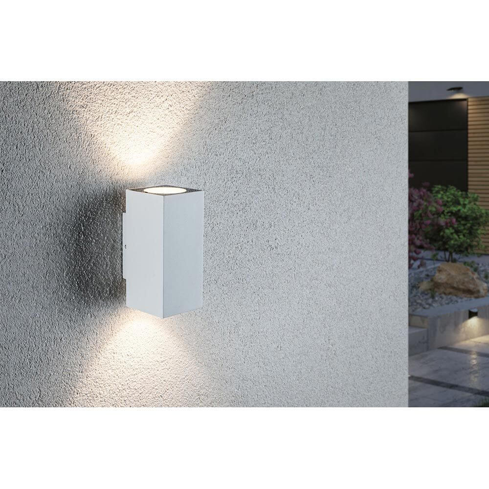 LED Außen Wandleuchte Flame Metall Weiß an einer Wand mit dekorativen Lichteffekten.