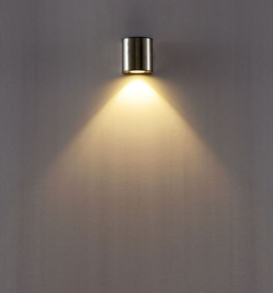 LED Außenwandleuchte Ilumi IP54 Chrom an einer Wand mit warmem Licht.