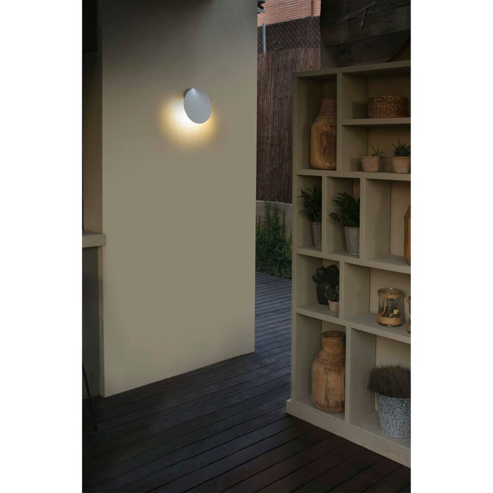 LED Außenwandleuchte LOTUS 3000K IP65 Weiß an Wand in modernem Außenbereich mit Regalen.