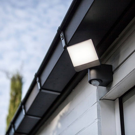 LED Projecteur extérieur Sunshine avec capteur IP44 Anthracite monté sur un mur de maison, diffuse une lumière homogène.