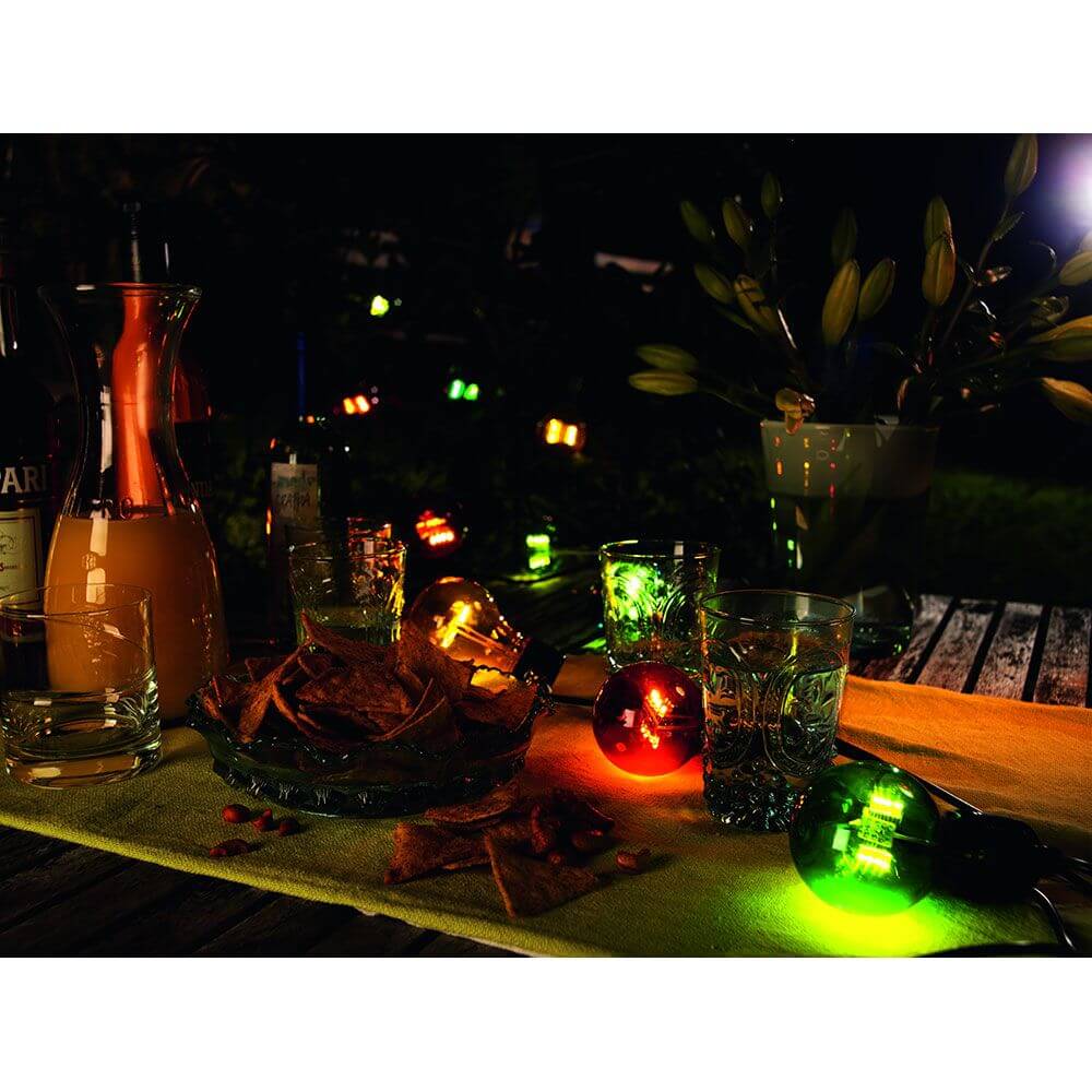 LED Biergartenkette 20er bunt 160 Warmweiße Dioden 24V auf einem Tisch mit Getränken und Snacks bei Nacht.