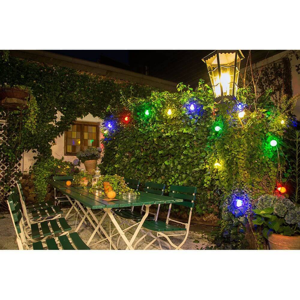 LED Biergartenkette 20er bunt milchig 160 Warmweiße Dioden 24V beleuchtet gemütlichen Gartenbereich bei Nacht.
