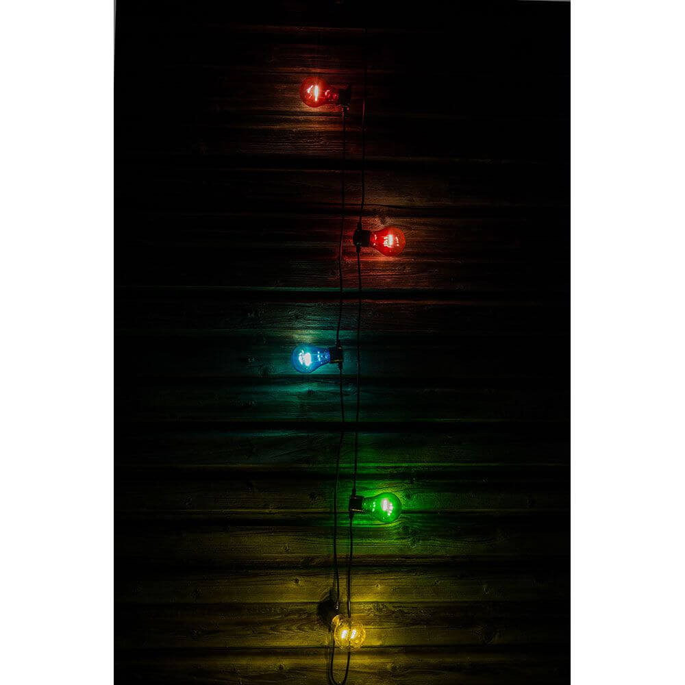 LED Biergartenkette 5er bunt 40 Warmweiße Dioden Batteriebetrieb an einer Wand mit leuchtenden Farben.