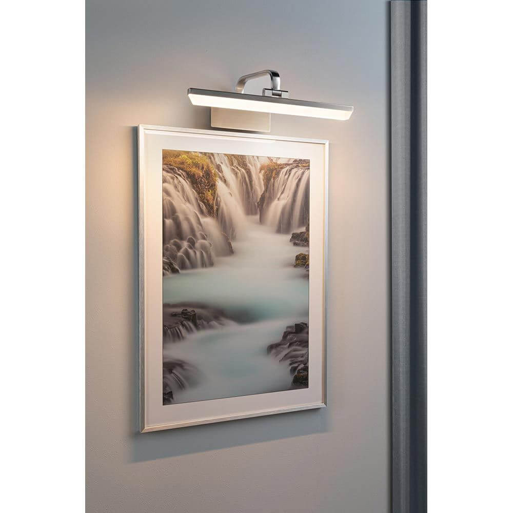 LED Spiegel- & Bilderleuchte Renan Alu-Gebürstet beleuchtet ein Kunstwerk an der Wand.