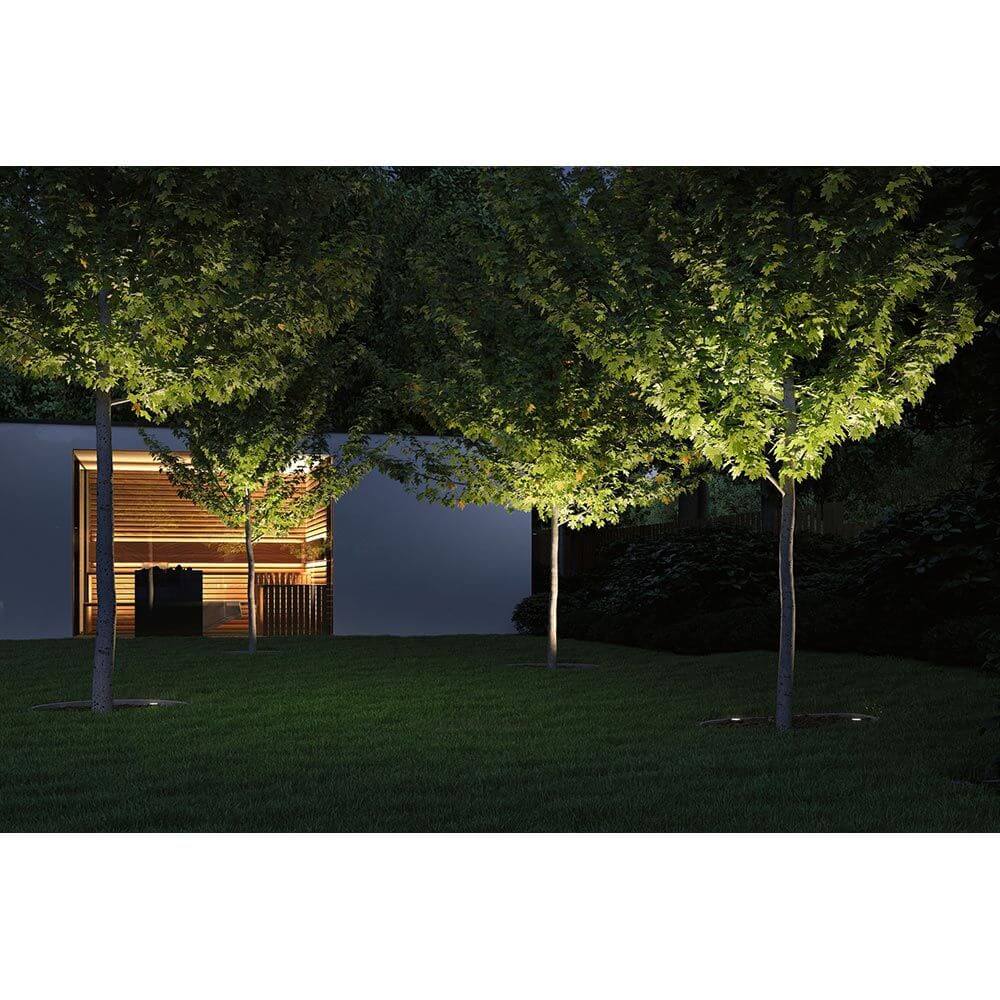 LED Bodeneinbauleuchte Floor Ø12cm Edelstahl IP67 beleuchtet Gartenweg unter Bäumen in der Dämmerung