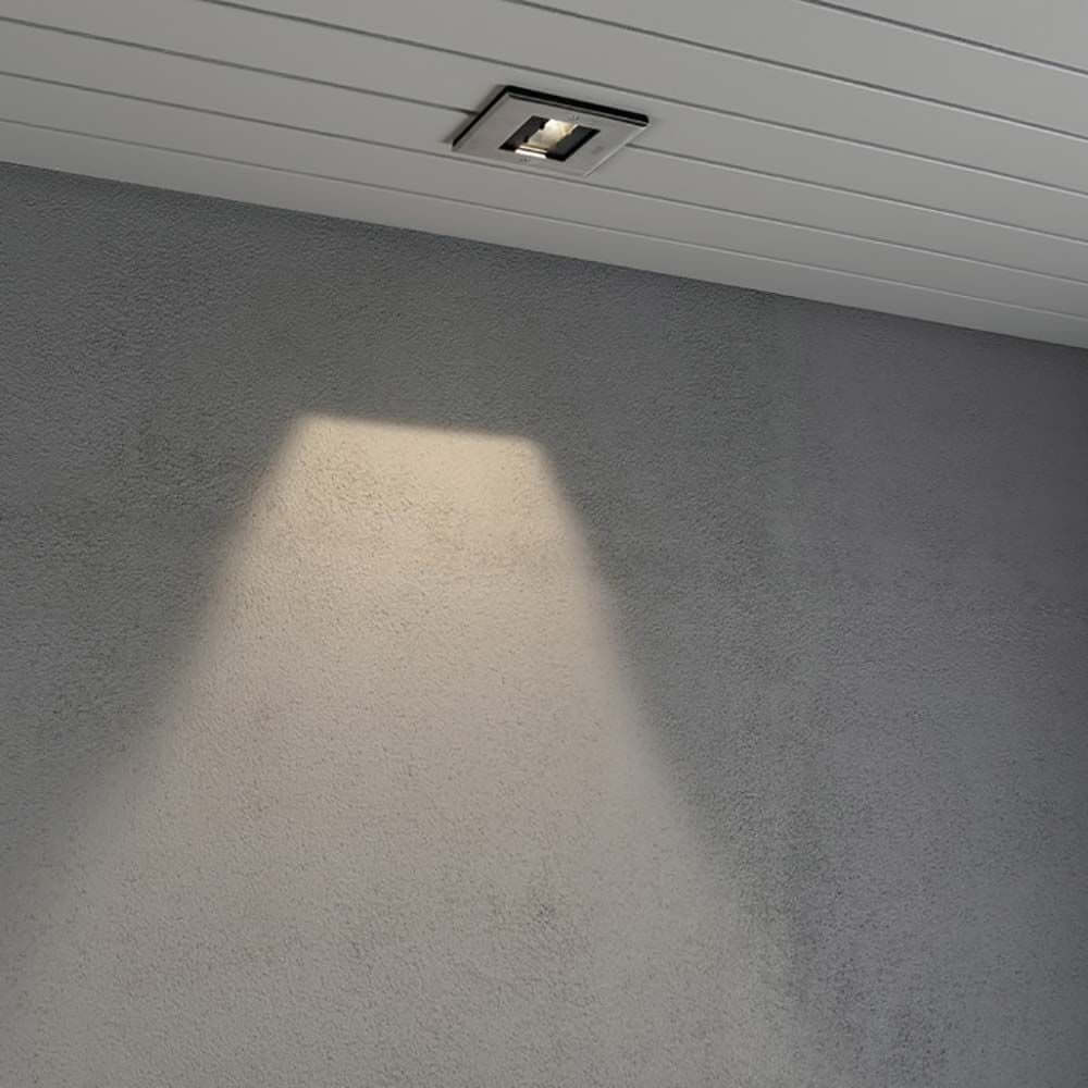 LED Decken Einbaustrahler IP44 strahlt Licht an die Wand auf grauem Untergrund.
