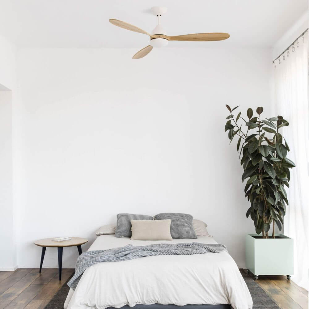 LED Deckenventilator Poros Ø 132cm Weiß über einem Bett in modernem Schlafzimmer mit Pflanzen.