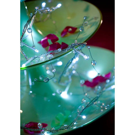 LED Dekolichterkette Acryl Perlen 32 Kaltweiße Dioden auf dekorativen Tellern mit Blumen und sanfter Beleuchtung.