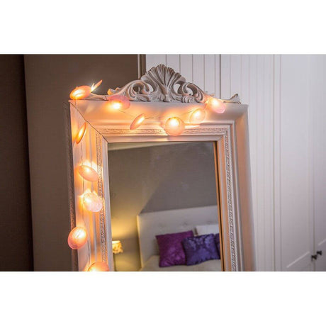 LED Decorative light string with mother-of-pearl petals, 20 warm white LEDs, battery-operated, decorated above a mirror.