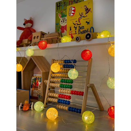 LED Dekolichterkette bunte Baumwollkugeln groß 16 Warmweiße Dioden dekoriert mit hölzernem Abakus und Spielzeug.