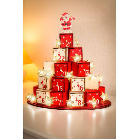 Adventskalender mit goldfarbener LED Dekolichterkette und Metallsternen auf rotem Tisch, festlich dekoriert.