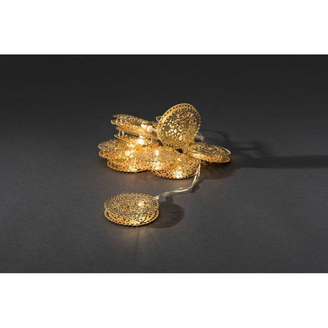LED Dekolichterkette goldfarbene Metalltaler 10 Warmweiße Dioden batteriebetrieben auf dunklem Hintergrund