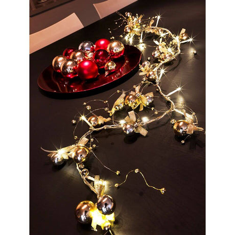 LED Dekolichterkette goldfarbene Perlen und Schleifen 20 Warmweiße Dioden auf festlich gedecktem Tisch mit Weihnachtsdeko