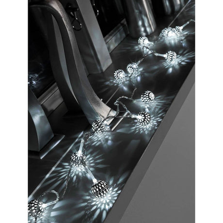 LED decorative light chain small silver-colored metal balls 10 cool white diodes battery-operated placed on a table.
