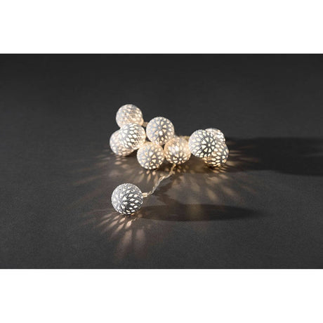 LED Decorative light chain with small white metal balls, 10 warm white diodes, battery-operated, on a dark background.