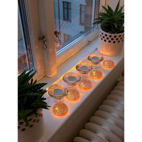 LED Dekolichterkette kupferfarbene Metalltaler 10 Warmweiße Dioden batteriebetrieben auf einem Fensterbrett mit Pflanzen.