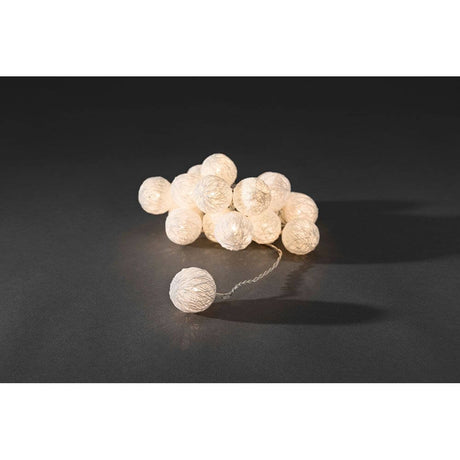LED Decorative string lights with small white cotton balls, 16 warm white diodes on a black background