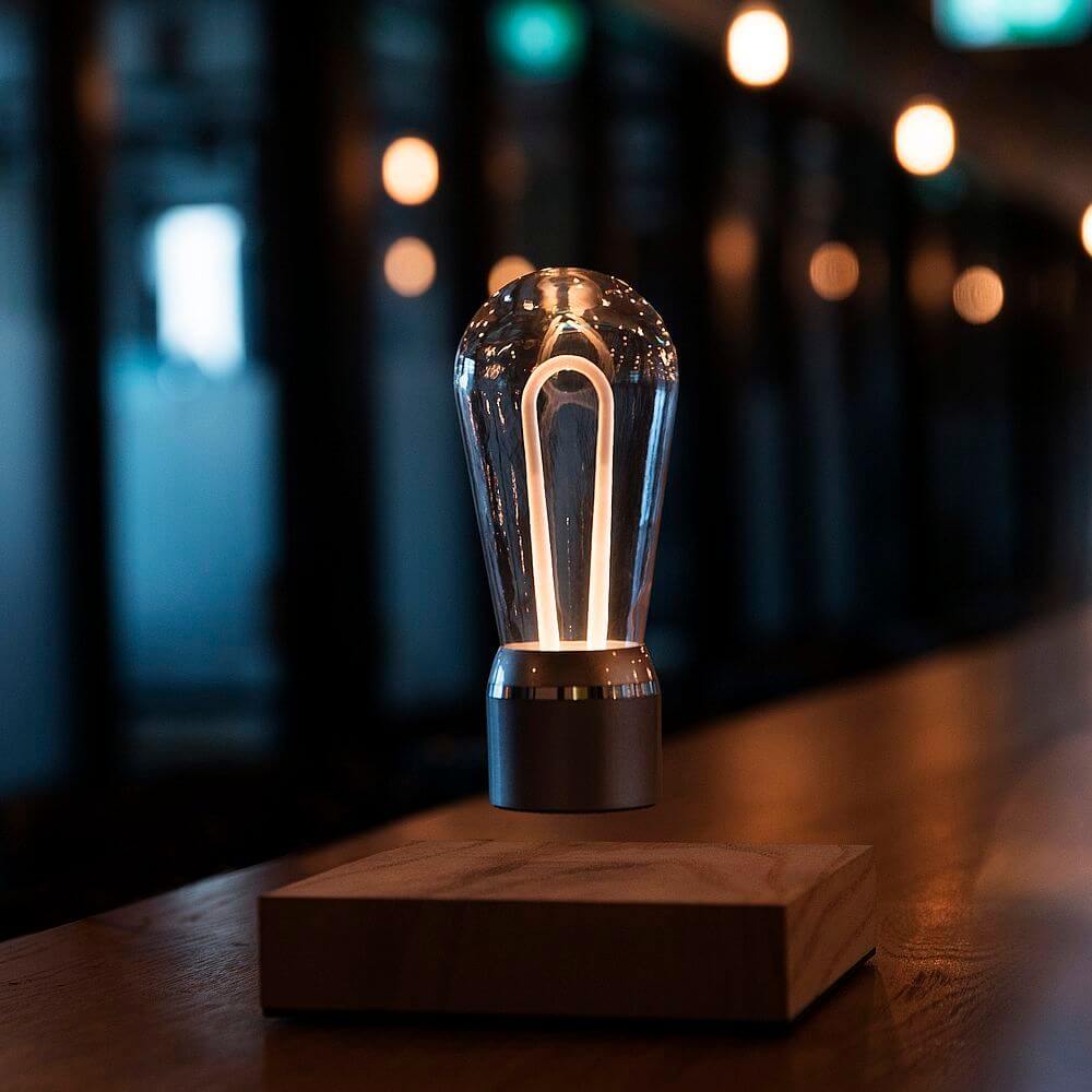 LED-Dekotischleuchte schwebende Glühbirne im Edison-Stil auf einem Holzsockel leuchtet sanft.
