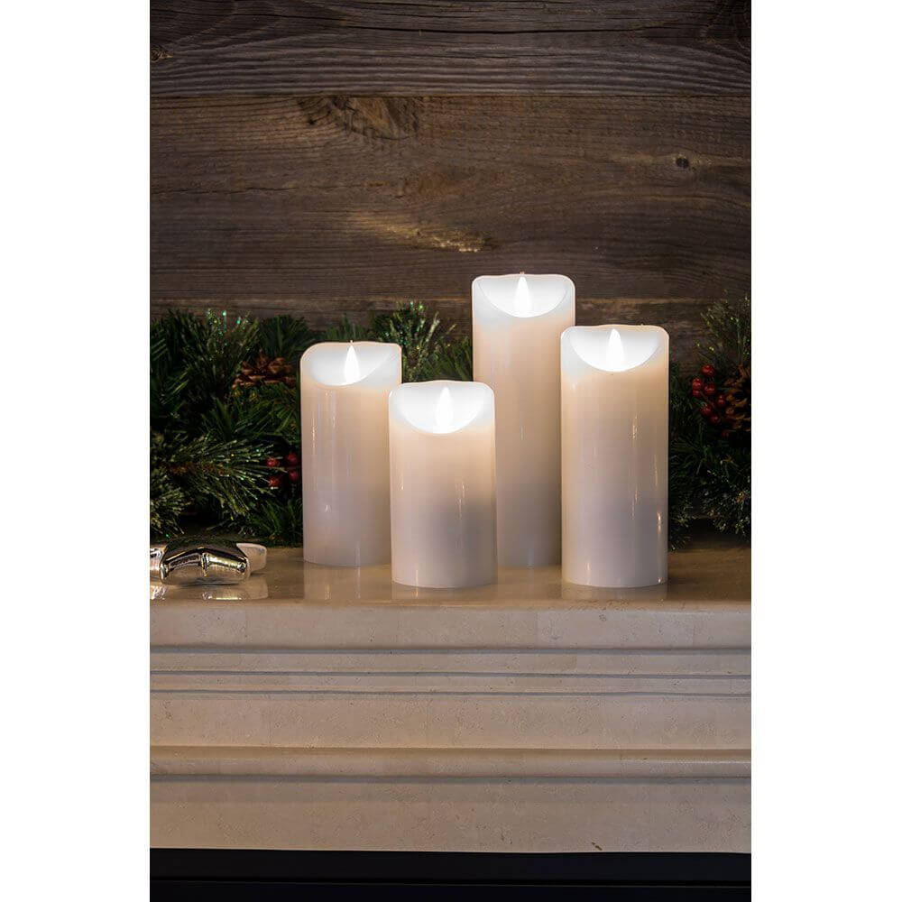 LED Echtwachskerze weiß mit 3D Flamme 20,5cm Timer Warmweiß batteriebetrieben auf einem Kaminregal.