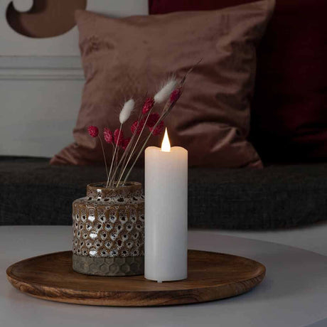 LED-ekte vokslys 4/8h timer batteridrevet hvit på et bord med dekorasjon.