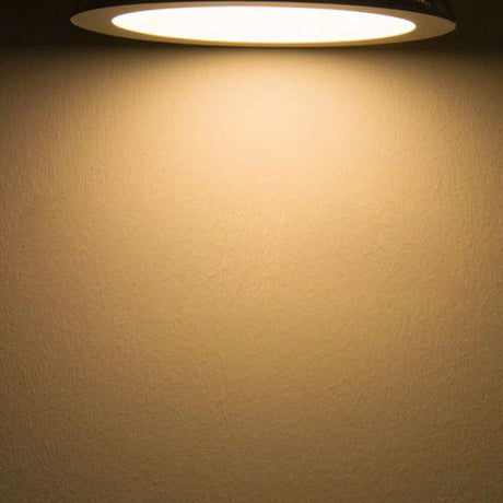 LED Forsænket panel Ø 22,5 cm flad rund sølv 18W varm hvid udstråler varmt lys på en væg.