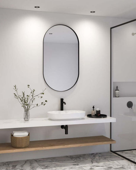 Modernes Badezimmer mit ovalem Spiegel, Waschbecken und minimalistischer Dekoration.