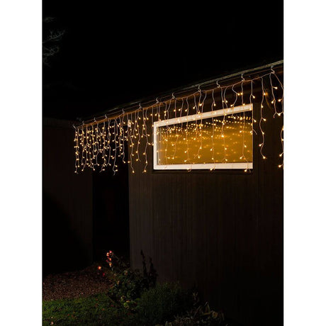 LED Eisregen Lichtervorhang 200 Globes Dioden Bernsteinfarben IP44 an einem Fenster im Dunkeln.