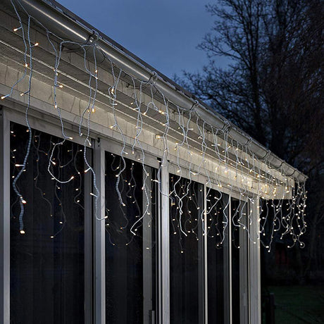 LED Eisregen Lichtervorhang Lichtsensor 240 bernsteinfarbene Dioden batteriebetrieb IP44 an einem Fenster angebracht.