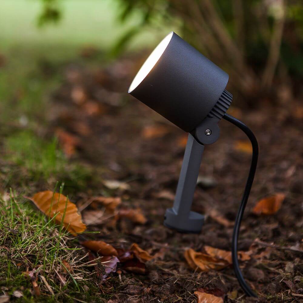 LED-Erdspieß Explorer schwenkbar auf einem Gartenboden zwischen Blättern.