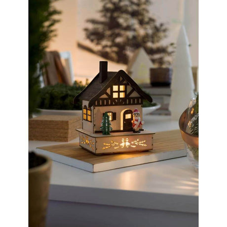 LED Holzsilhouette Fachwerkhaus Weihnachtsbaum und pinker Figur warmweiß batteriebetrieb in festlicher Weihnachtsdekoration.