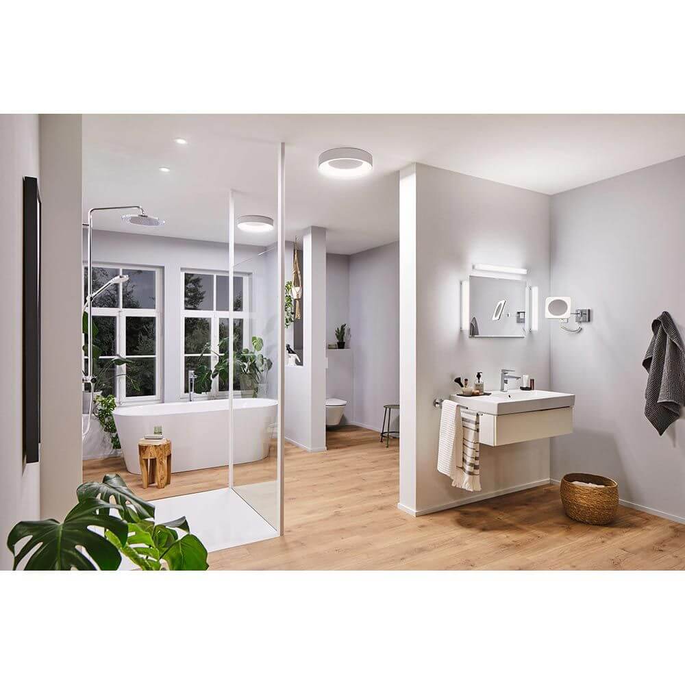 Moderne Badezimmeransicht mit LED Einbauleuchte Calla, Dusche und Badewanne, Holzdetails und Pflanzen.
