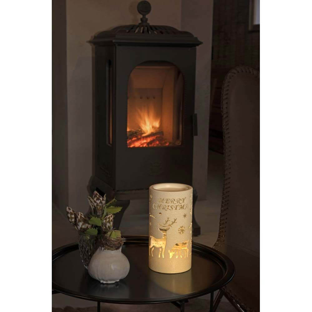 LED Laterne Rentier Weihnachtsmann und Schlitten Zylinderform Timer warmweiß batteriebetrieben auf Tisch vor Kamin.