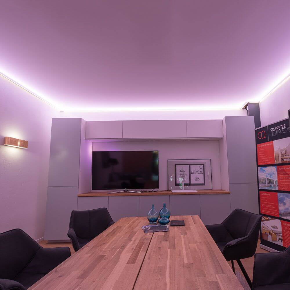 Moderne LED-Lichtdecke mit RGBW-Beleuchtung in einem stilvollen Wohnraum mit Holztafel.
