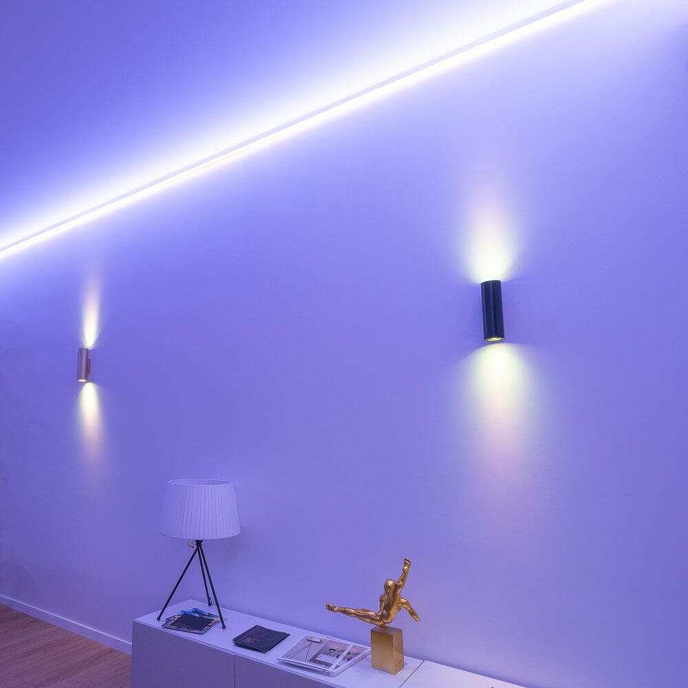 Moderne LED-Beleuchtung an einer Wand mit warmweißen und blauen Lichtern in einem Wohnraum.