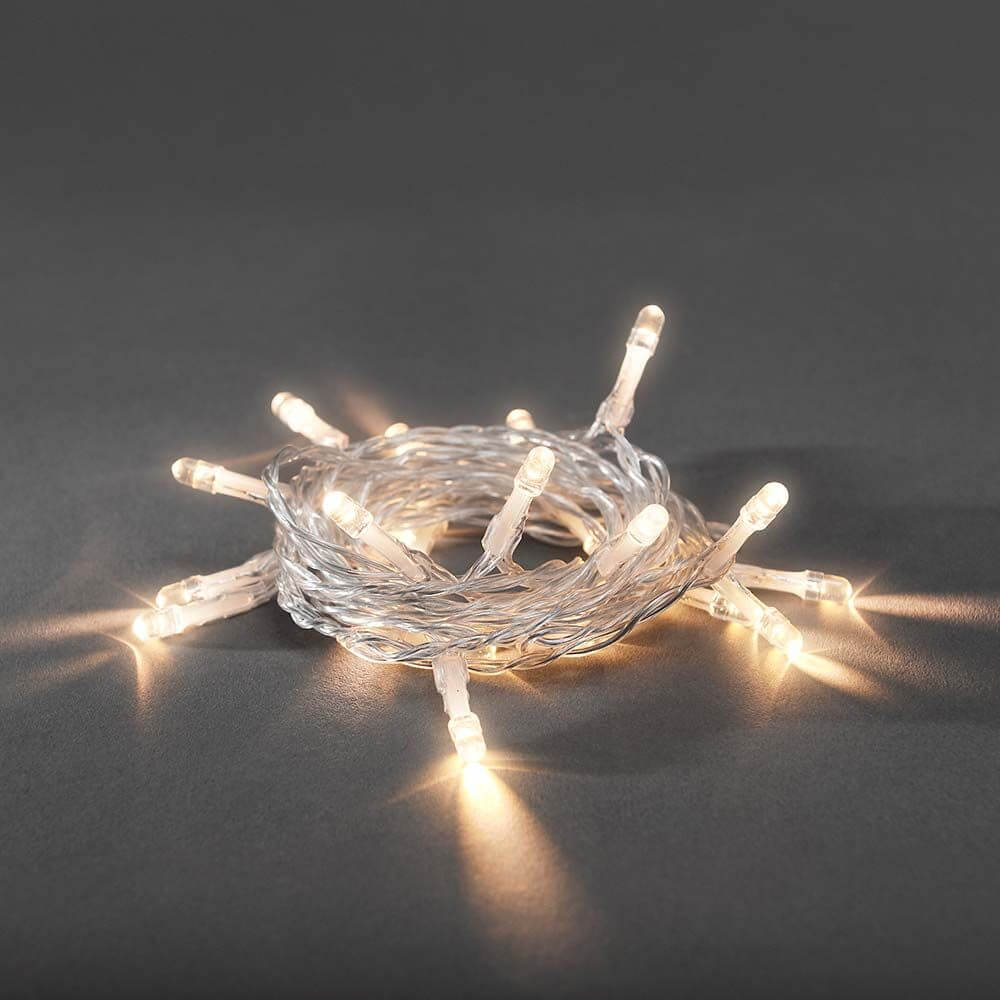 LED Lichterkette 10 Warmweiße Dioden batteriebetrieben auf dunklem Hintergrund, ideal für festliche Dekoration.