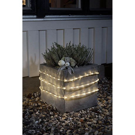 LED-lysslange 6 m sensor 96 varmhvite dioder IP44 dekorerer en plantekasse med planter.