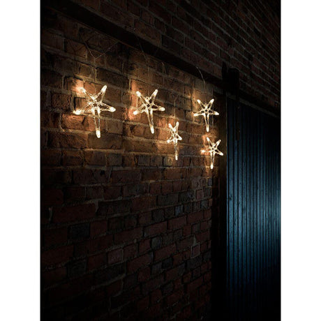 LED Lichtervorhang 5 Acrylsterne 40 Warmweiße Dioden IP44 an einer Backsteinwand dekoriert.