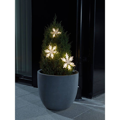 Tenda luminosa LED 3 fiocchi di neve bianco caldo a batteria IP44 su un albero di Natale in vaso.