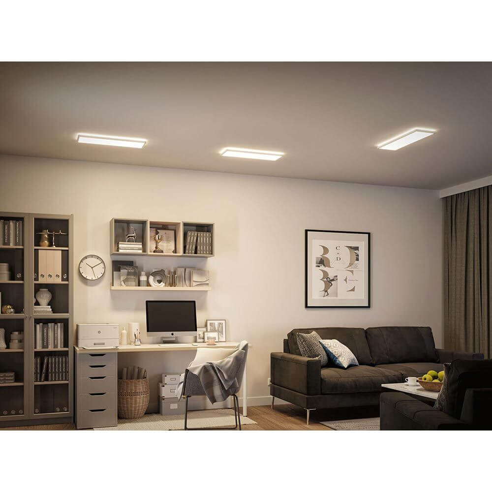 LED Panel Atria Shine Wärme-Dimmbar Weiß in einem modernen Wohnraum mit Schreibtisch und gemütlichem Sofa.