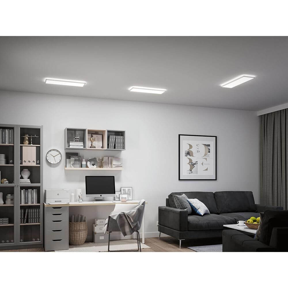 LED Panel Atria Shine Wärme-Dimmbar Weiß in modernem Wohnraum mit Schreibtisch und Sofa.