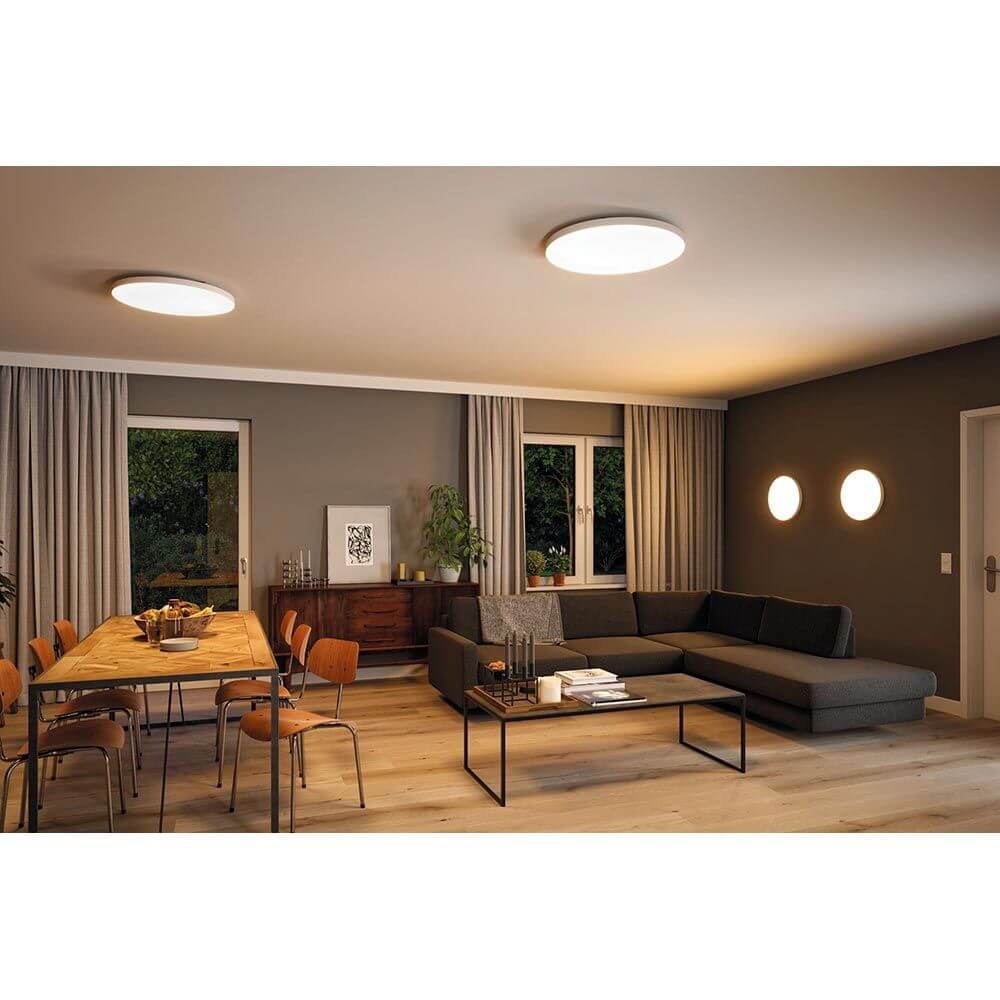 LED Panel Smart Home Zigbee Velora CCT Rund 40cm Weiß in modernem Raum über Essbereich und Sofa installiert.