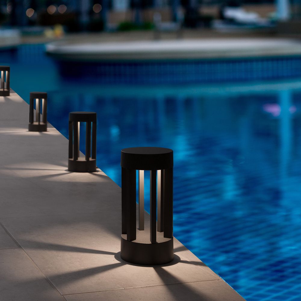 Moderne LED Pollerleuchte Devora 22cm Dunkelgrau, beleuchtet den Weg am Pool, erzeugt stimmungsvolle Lichteffekte.