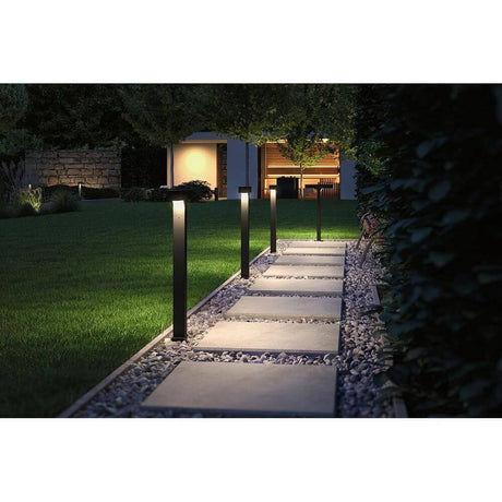 LED Pollerleuchte Dobla Anthrazit Aluminium beleuchtet einen Weg in einem Garten.