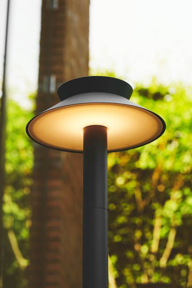 LED Pollerleuchte Justina Solar IP44 mit klassischem Design und Bewegungssensor in naturnahem Umfeld.